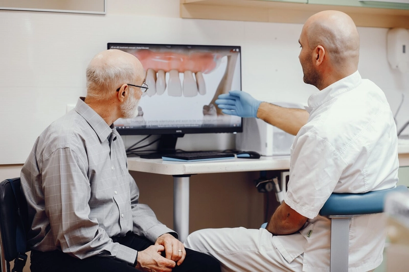 Dentist explaining dental implant costs to an elderly patient at Tooth Implant Sydney.