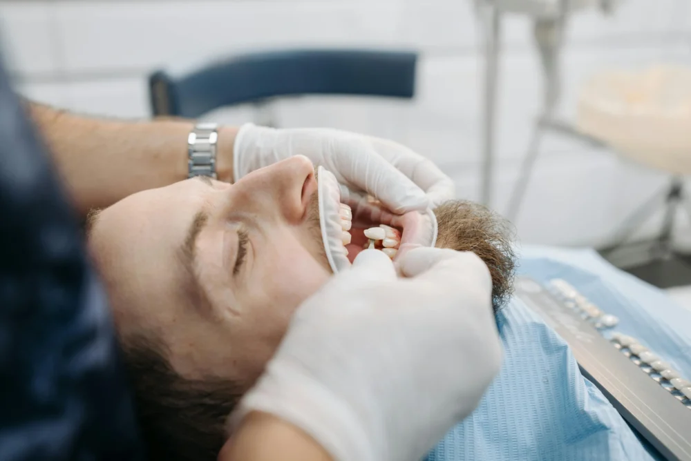 Male patient undergoing a single tooth dental implant restoration procedure at a clinic.